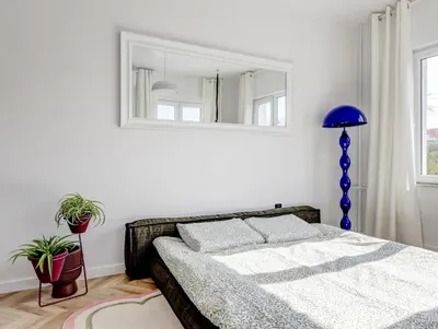 a bedroom with a bed with a blue lamp and a mirror at Quiet Elegance in Sofia Center in Sofia