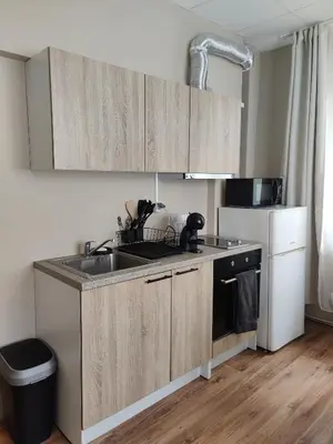 a kitchen with wooden cabinets and a sink and a stove at Тристаен апартамент in Elin Pelin
