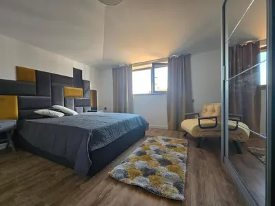 a bedroom with a bed and a chair and a rug at KS Gondola point apartment in Bansko