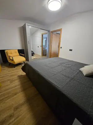 a bedroom with a large bed and a chair at KS Gondola point apartment in Bansko