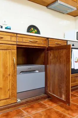 a kitchen with a white dishwasher in a wooden cabinet at Stancho's House 3BR apartment close to OLD TOWN & KAPANA district in Plovdiv