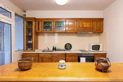 a kitchen with wooden cabinets and a wooden table at Stancho's House 3BR apartment close to OLD TOWN & KAPANA district in Plovdiv