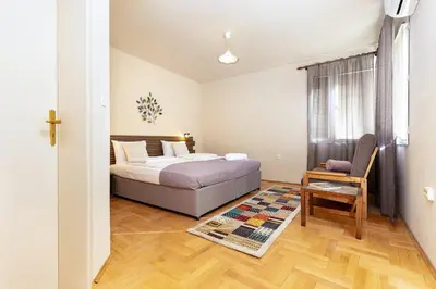 a bedroom with a bed and a chair and a table at Stancho's House 3BR apartment close to OLD TOWN & KAPANA district in Plovdiv