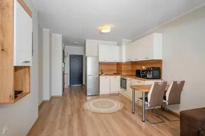 a kitchen with white cabinets and a table and chairs at 1BD Apartment in Sofia City Center by Flat Mаnаger in Sofia