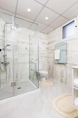 a bathroom with a glass shower and a toilet at City Castle apartment 3BR in central Plovdiv in Plovdiv