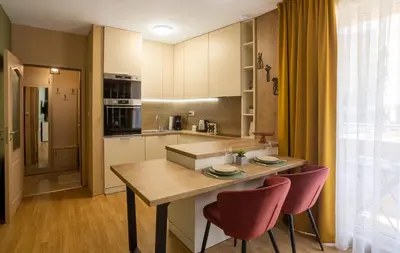 a kitchen with a wooden table and two pink chairs at Domus Magnolia Studio In The Top Center in Plovdiv