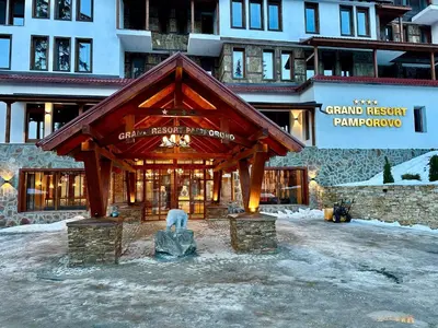 a building with a wooden structure in the snow at Tulip Apartment High-End, Grand Resort Pamporovo in Pamporovo