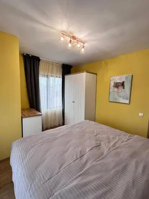 a bedroom with a large bed with yellow walls at Spacious sunny flat with 2 bedrooms in the heart of Plovdiv in Plovdiv
