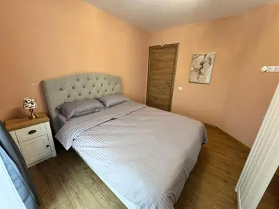 a small bedroom with a bed and a wooden floor at Spacious sunny flat with 2 bedrooms in the heart of Plovdiv in Plovdiv