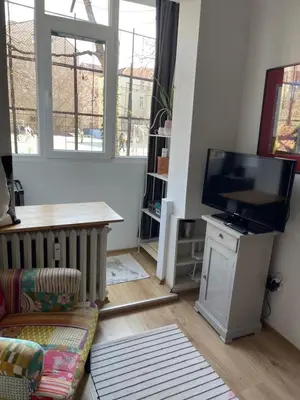 a living room with a couch and a television at Nice and cozy in Sofia