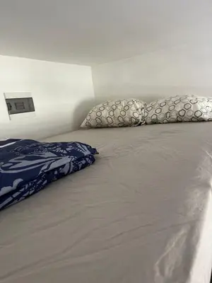 a bed with two pillows on top of it at Nice and cozy in Sofia