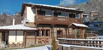 a house in the snow with a wooden fence at Капсъзовата къща in Leshten