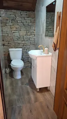 a bathroom with a white sink and a toilet at Капсъзовата къща in Leshten