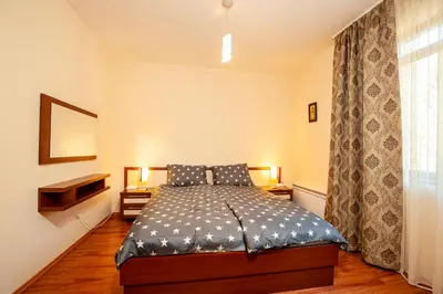a bedroom with a bed and a television and a window at Гнездото на Гълъба in Ostrets