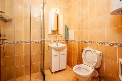 a bathroom with a toilet and a sink at Гнездото на Гълъба in Ostrets