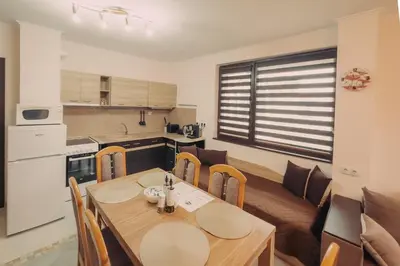 a kitchen and dining room with a wooden table and chairs at Apartment Aria 5 in Velingrad