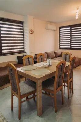 a wooden table and chairs in a living room at Apartment Aria 5 in Velingrad