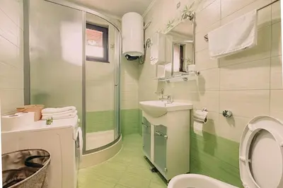 a white bathroom with a sink and a toilet at Apartment Aria 5 in Velingrad