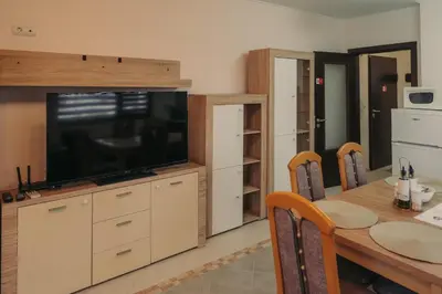 a dining room with a table and a large television at Apartment Aria 5 in Velingrad