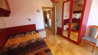 a small bedroom with a bed and a mirror at Malina Apart in Plovdiv