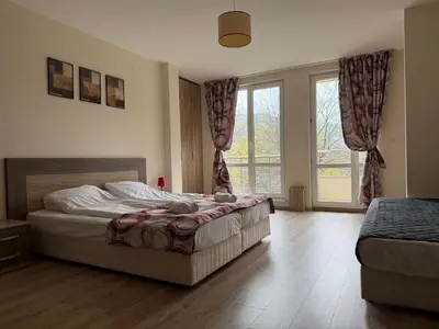 a bedroom with a bed and a large window at Green View Studios in Sandanski