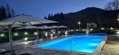 a large swimming pool with umbrellas and a resort at Къща за гости Брязово in Ribarica