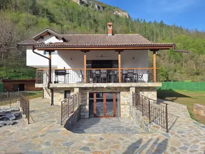 a large house with a balcony and a mountain at Къща за гости Брязово in Ribarica