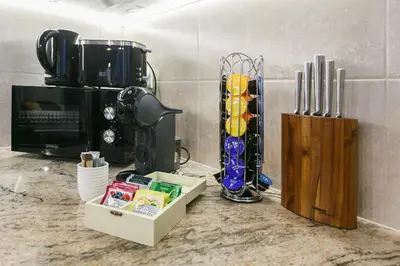 a kitchen counter with a coffee maker and a microwave at Klimt's Puzzle Suite in Sofia
