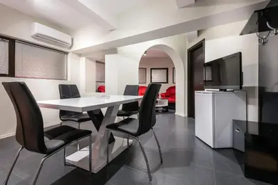 a dining room with a white table and black chairs at Hotel-Restaurant DIMAX in Yoakim-Gruevo