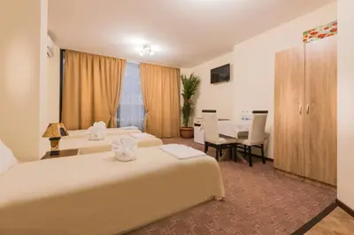 a hotel room with two beds and a table at Hotel-Restaurant DIMAX in Yoakim-Gruevo
