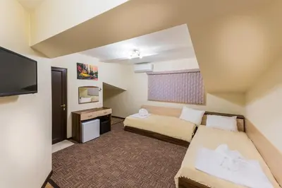 a hotel room with two beds and a flat screen tv at Hotel-Restaurant DIMAX in Yoakim-Gruevo