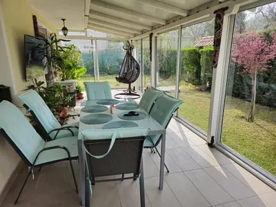 a table and chairs on a screened in porch at Къща за гости Спирката in Spatovo