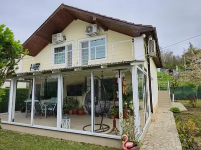 a house with a conservatory with sliding glass doors at Къща за гости Спирката in Spatovo