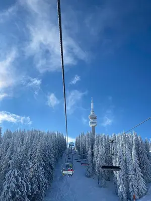 a ski lift with snow covered trees and a tower at Ski & View Pamporovo Apartment in Smolyan