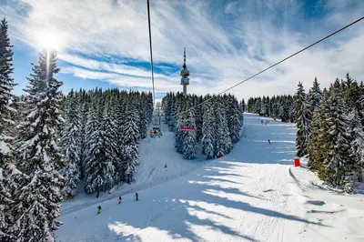 a ski slope with people on a ski lift at Ski & View Pamporovo Apartment in Smolyan