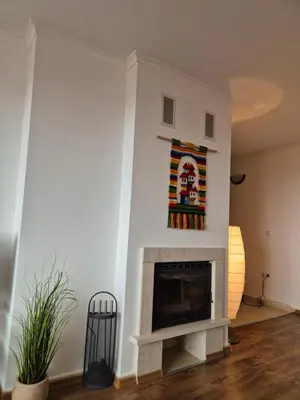 a living room with a fireplace and a painting on the wall at Ski & View Pamporovo Apartment in Smolyan