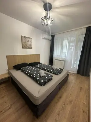 a bedroom with a bed with black pillows on it at The View Residences & private parking in Sofia
