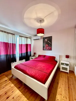 a bedroom with a large bed with a red blanket at Mary's Guesthouse in Banya