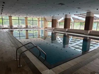 a large swimming pool in a building with windows at Donna Spa hotel Sveti Spas in Velingrad