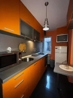 an orange kitchen with a sink and a microwave at Sofia Central Cozy Apartment in Sofia