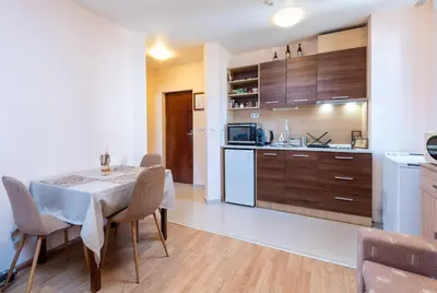 a kitchen and dining room with a table and chairs at Cozy Mountain-View Apartment in Belmont, Bansko by Flat Mаnager in Bansko