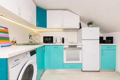 a kitchen with blue cabinets and a washer and dryer at Plovdiv Urban Gem Studio by Flat Mаnаger in Plovdiv
