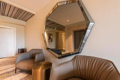 a living room with a couch and a mirror at Saint Sofia Golf Club, Hotel and SPA in Robertowo