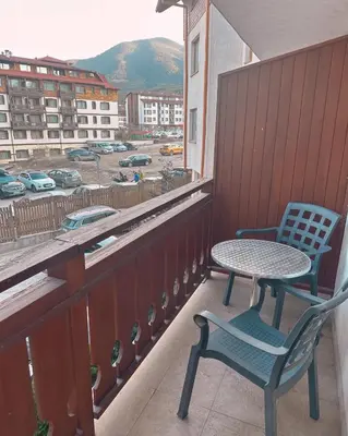 a table and chairs on a balcony with a view of a city at Ski Lift Apartment in Bansko