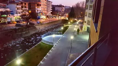a city street at night with a river and buildings at 