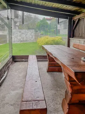 a wooden table and bench sitting inside of a porch at Tarein Studio in Bansko