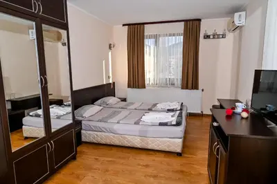 a bedroom with a bed with a mirror and a desk at Хотел Валентино 2 in Dobrinishte