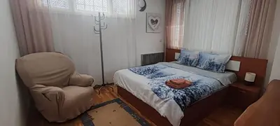 a small bedroom with a bed and a chair at Apartment Sofia View with Rooftop Terrace in Sofia