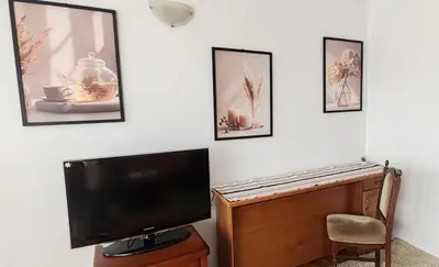 a flat screen tv sitting on top of a wooden table at Apartment Sofia View with Rooftop Terrace in Sofia