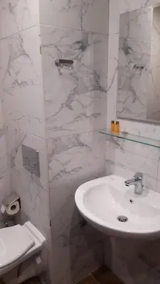 a white bathroom with a sink and a toilet at ТЕС Боровец Гарденс in Borovets